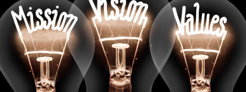 Light Bulbs Concept Photo of light bulbs with shining fibers in MISSION, VISION, VALUES shape on black background